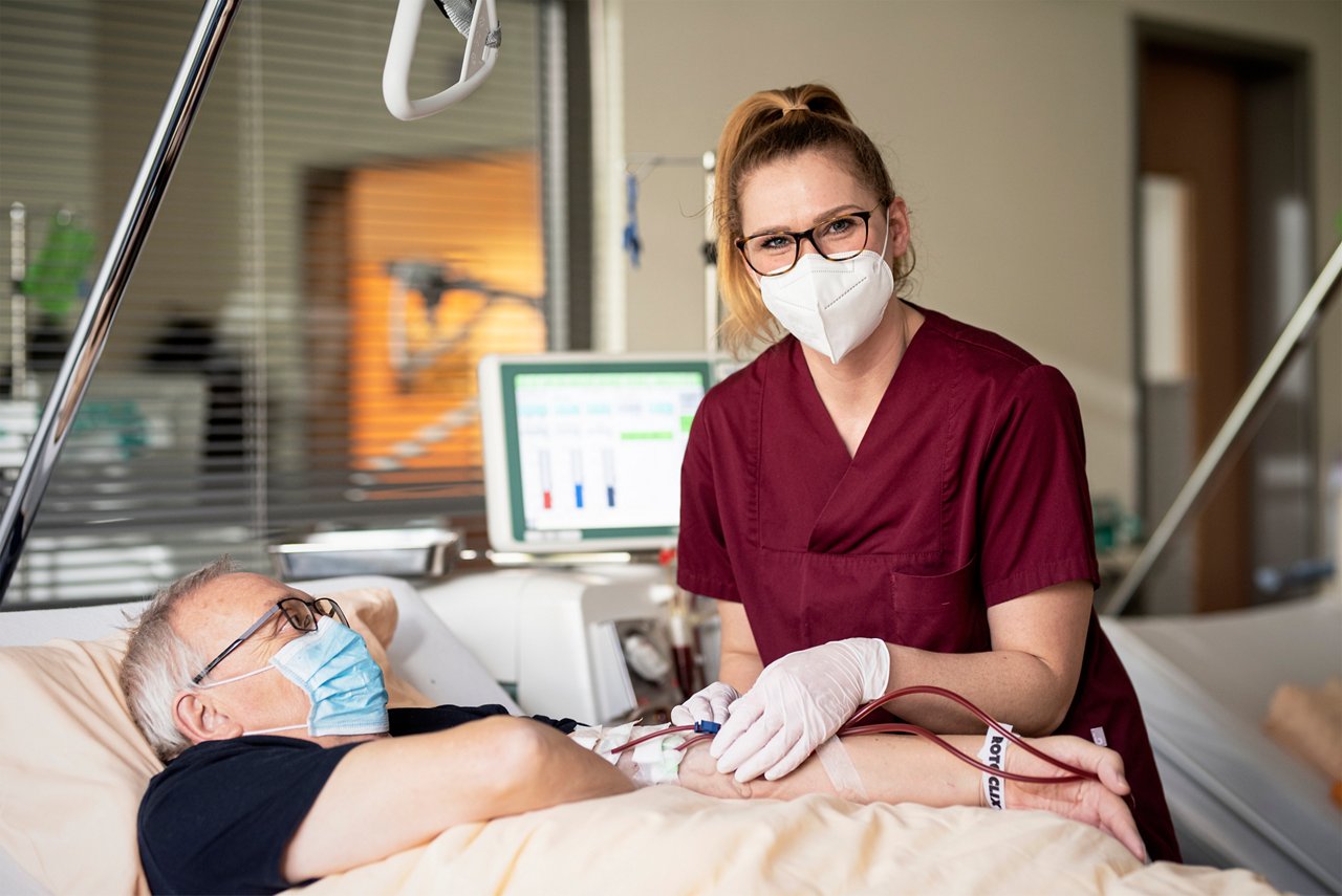 Eine Pflegerin kontrolliert die Dialyse bei einem Patienten