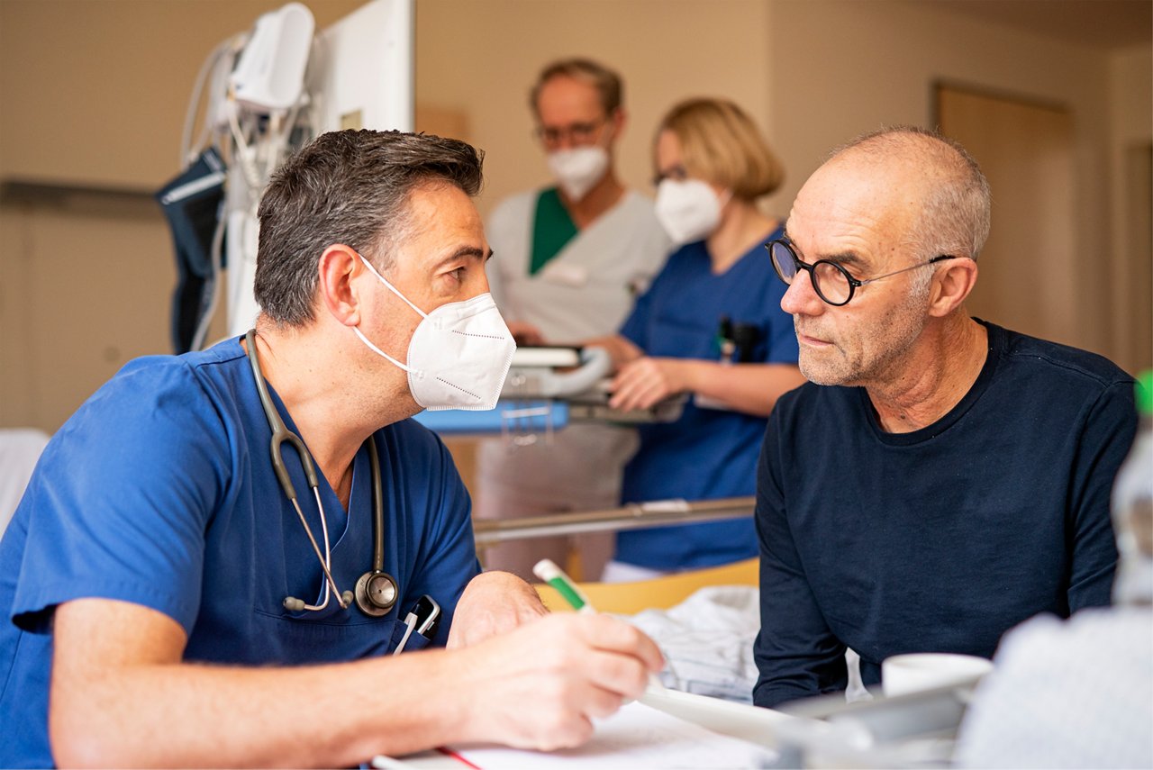 Ein Gefäßchirurg im Gespräch mit einem Patienten