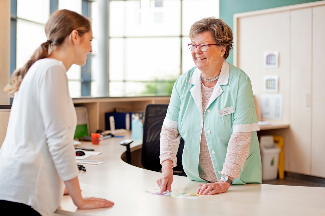 Gruene Dame vom ehrenamtlichen Besuchsdienst im Gespraech am Infopoint in Krefeld