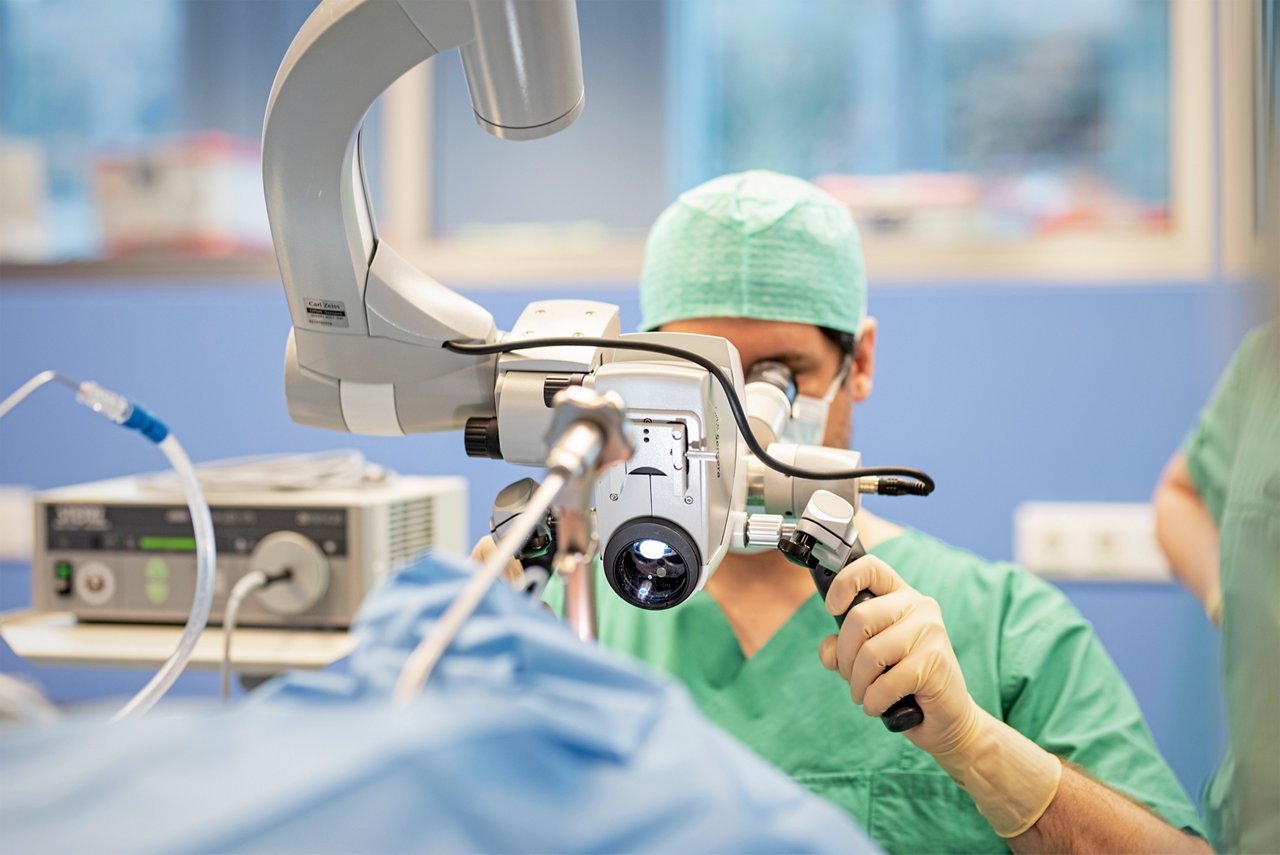 Ein HNO-Arzt blickt durch ein OP-Mikroskop