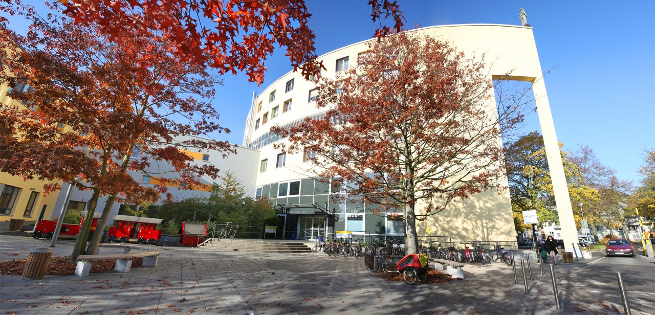Ärztin mit Kleinkind auf dem Arm auf dem Stationsflur