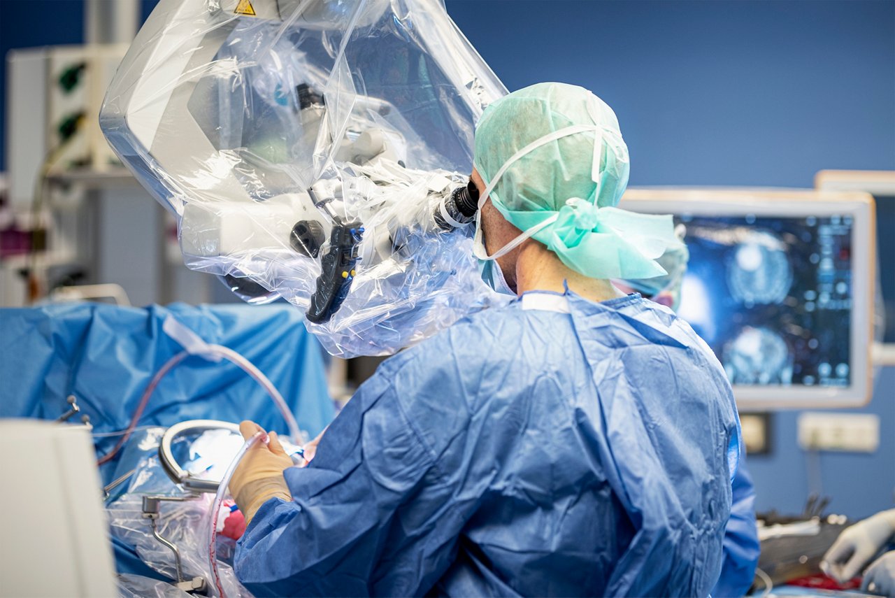 Neurochirurg bei einer Hirntumor-OP mit Mikroskop