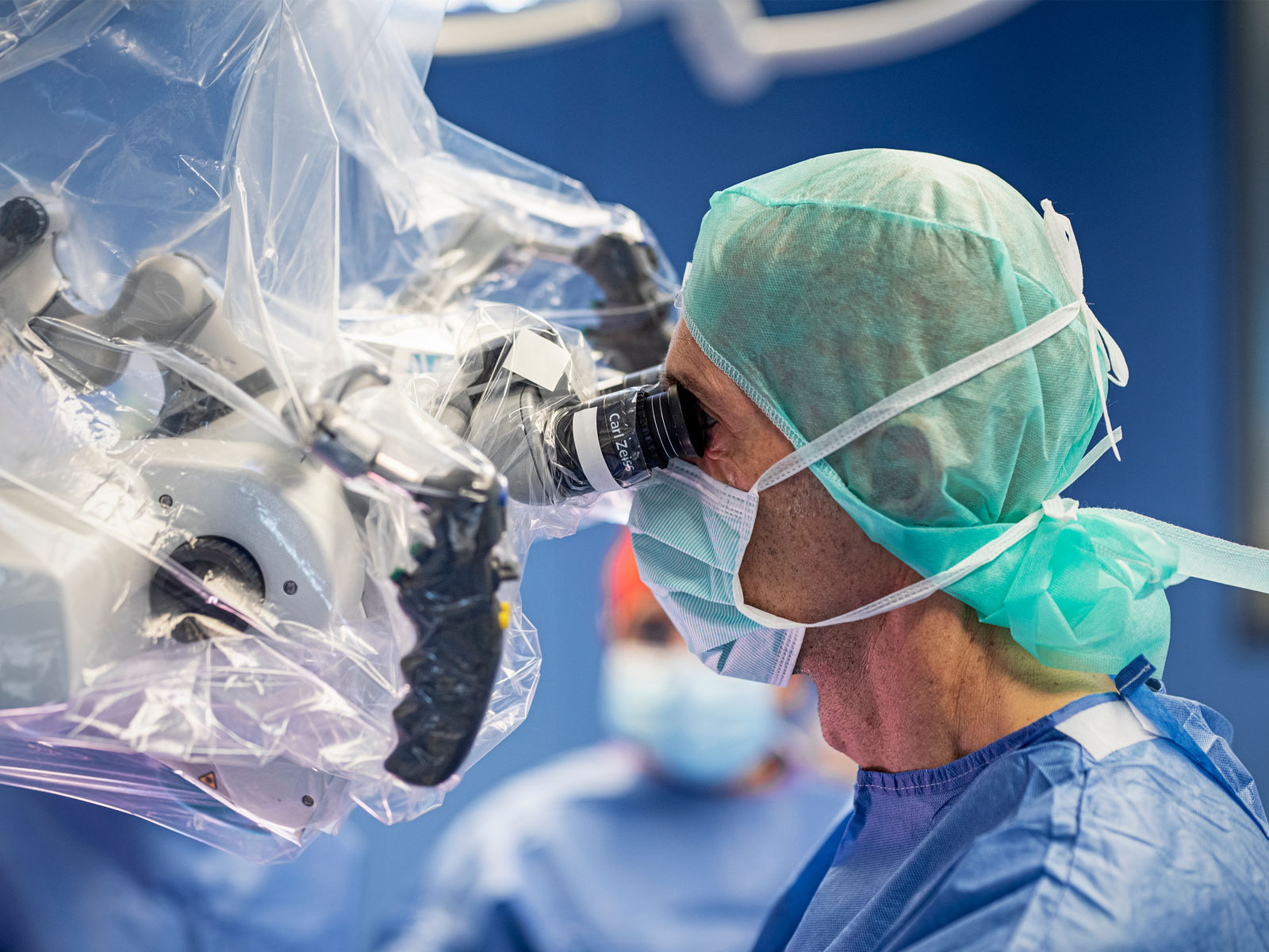 Nahaufnahme einer Neurochirurgen, der durch ein OP-Mikroskop blickt