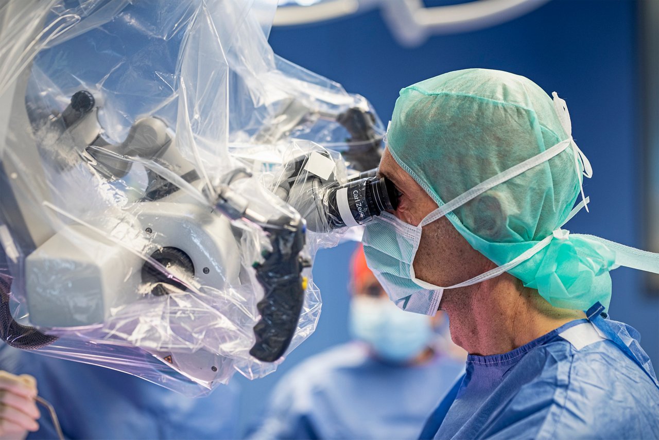 Nahaufnahme einer Neurochirurgen, der durch ein OP-Mikroskop blickt