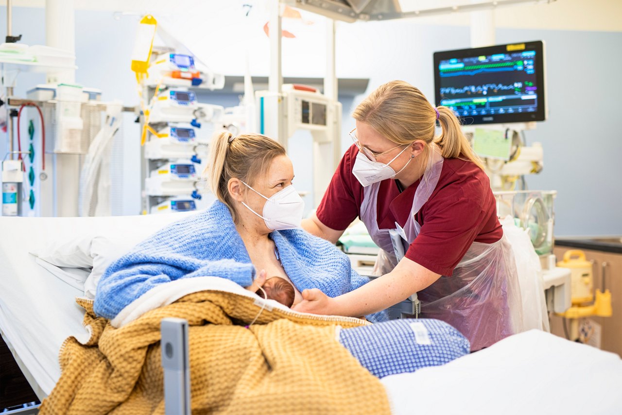 Mutter und Baby mit Stillberaterin im Kreißsaal