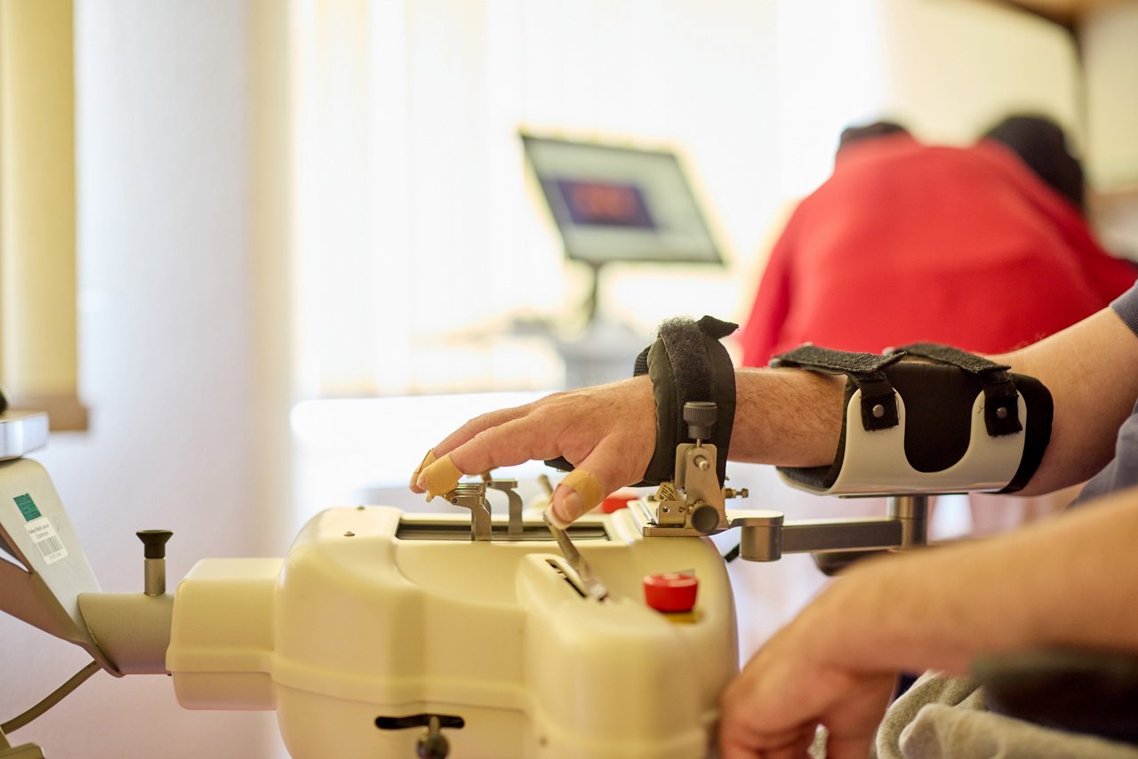 Patient an einem Trainingsgerät für Handmuskulatur und Koordination