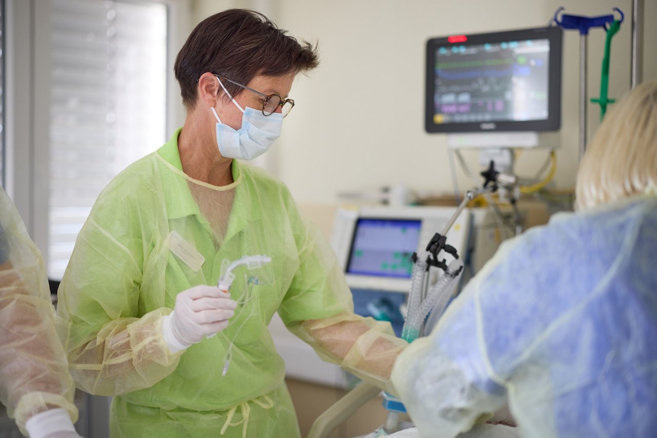 Logopädin setzt eine Trachealkanüle bei einem Patienten ein