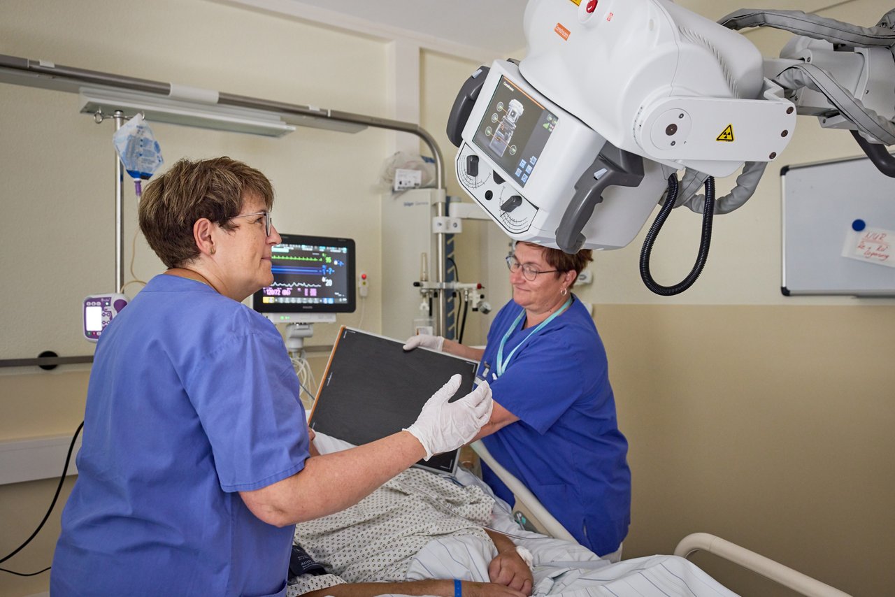 MTRAs röntgen Patienten mit mobilem Gerät auf seinem Zimmer
