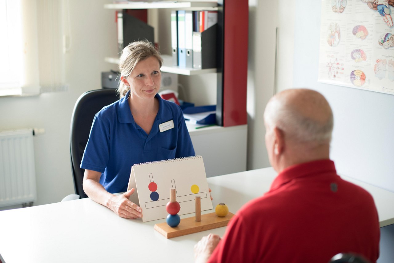Neuropsychologin testet Aufmerksamkeit und kognitive Fähigkeiten eines Patienten.