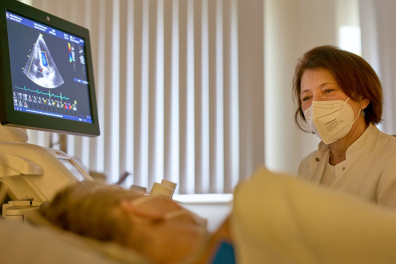Ärztin führt Sonographie bei einer Patientin durch und bespricht das Bild