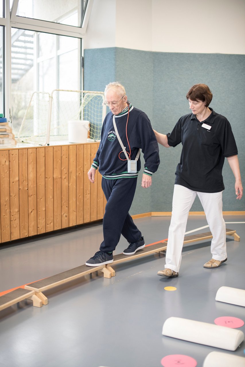 Sporttherapeutin trainiert das Gleichgewicht ihres Patienten