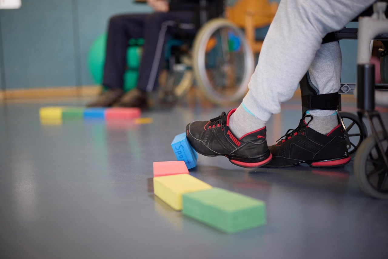 Rollstuhlfahrer beim Koordinationstraining während einer Sporttherapie