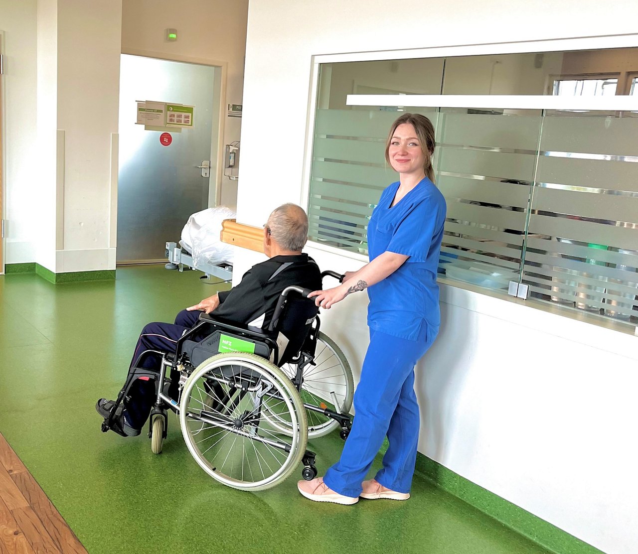 Pflegekraft mit Patient im Rollstuhl