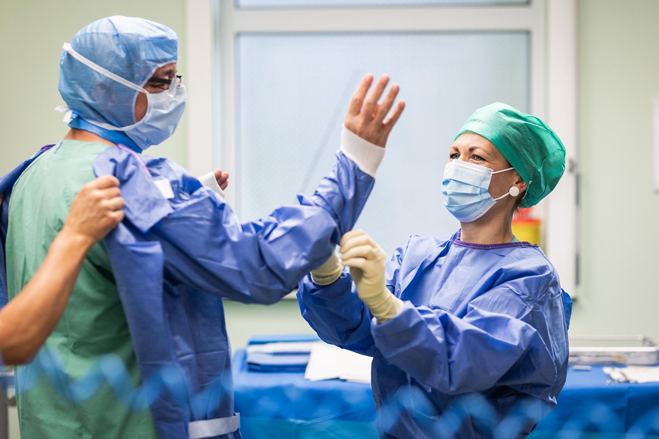 Unterstützung bei Anziehen der Schutzkleidung