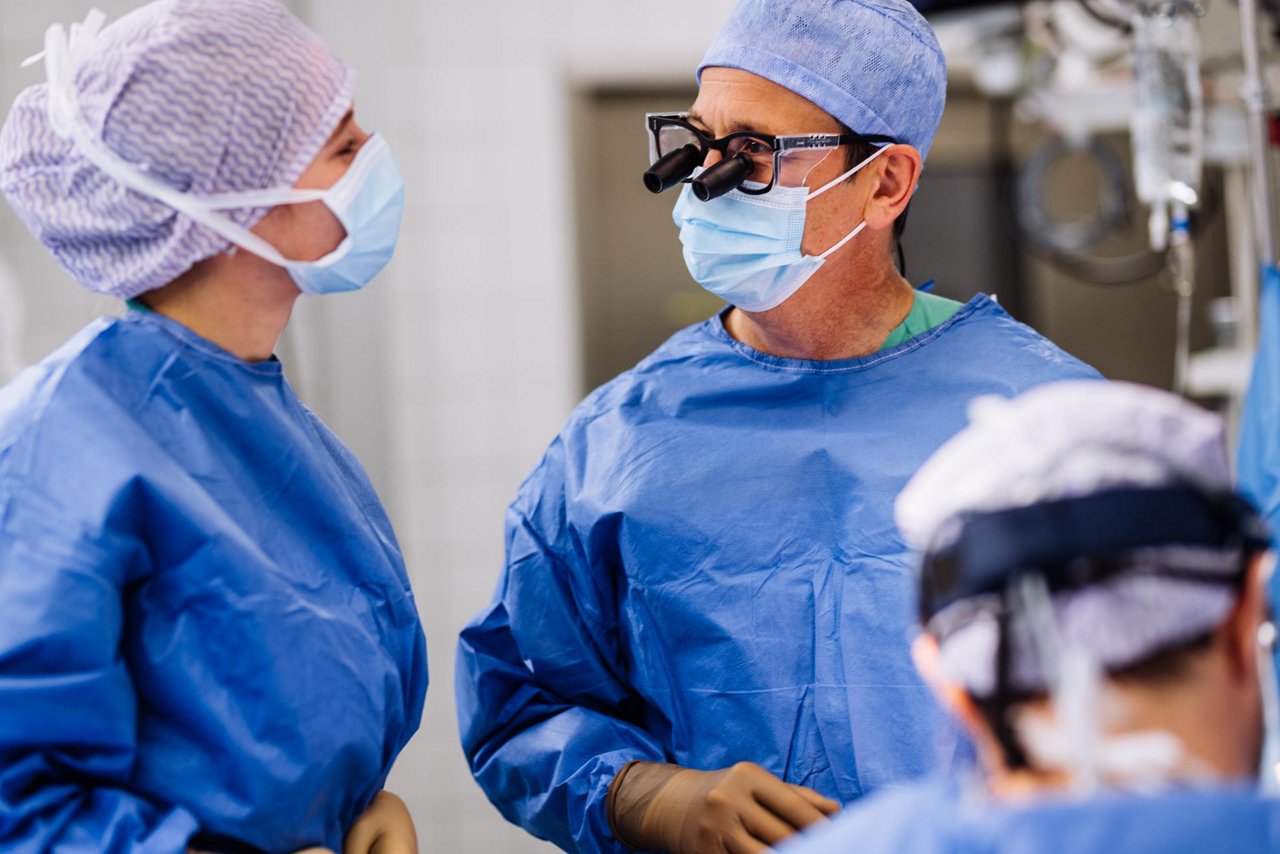 Pfleger gießt Opa etwas zu trinken ein