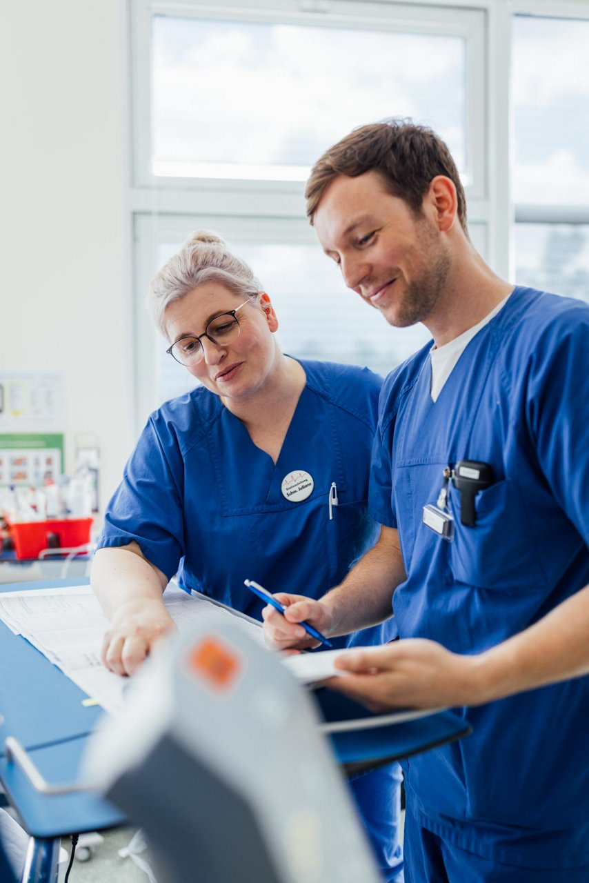 Visite am Patientenbett mit Arzt und Intensivpflegekraft