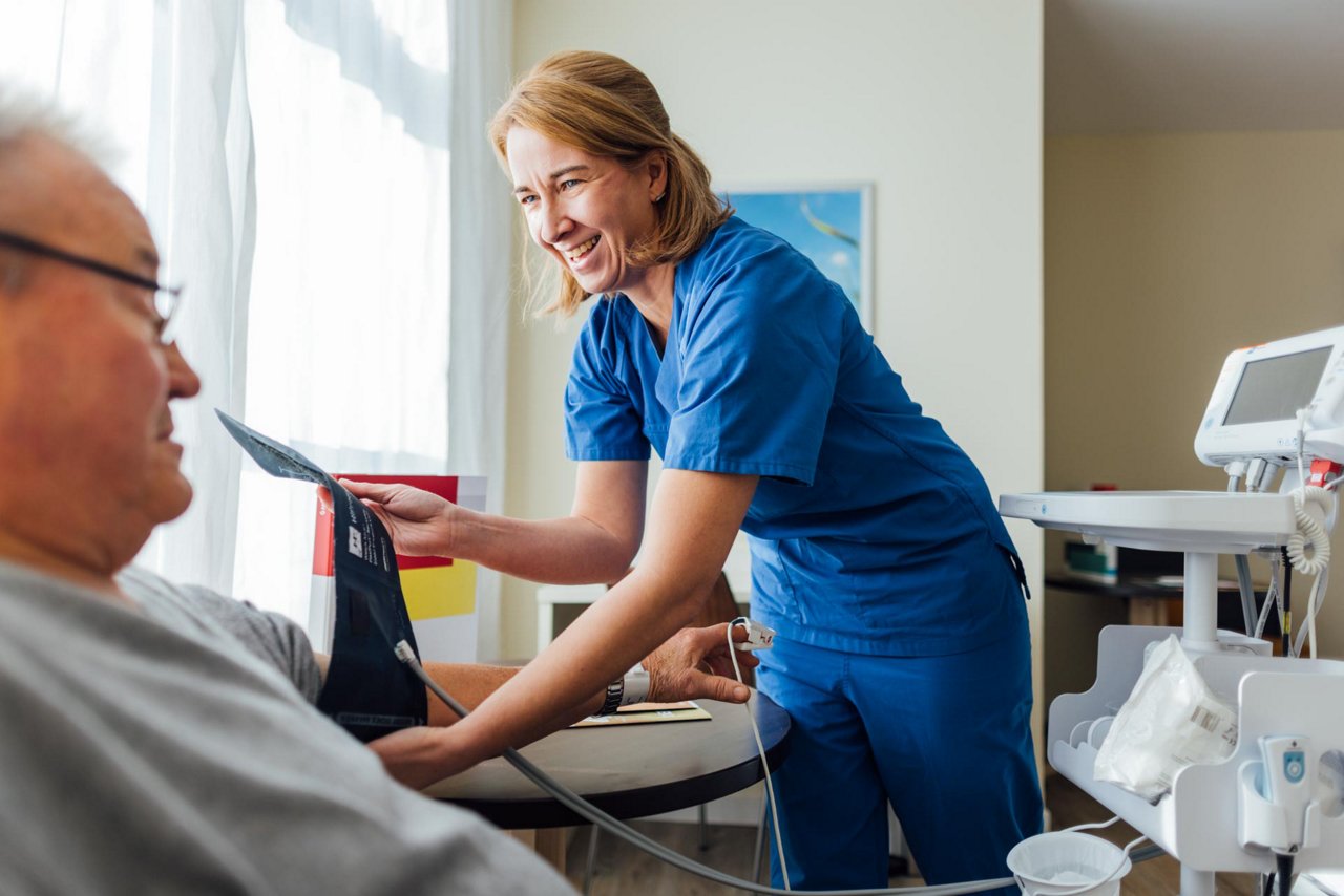 Pflegefachkraft untersucht auf Wahlleistungsstation vom Herzzentrum einen Patienten
