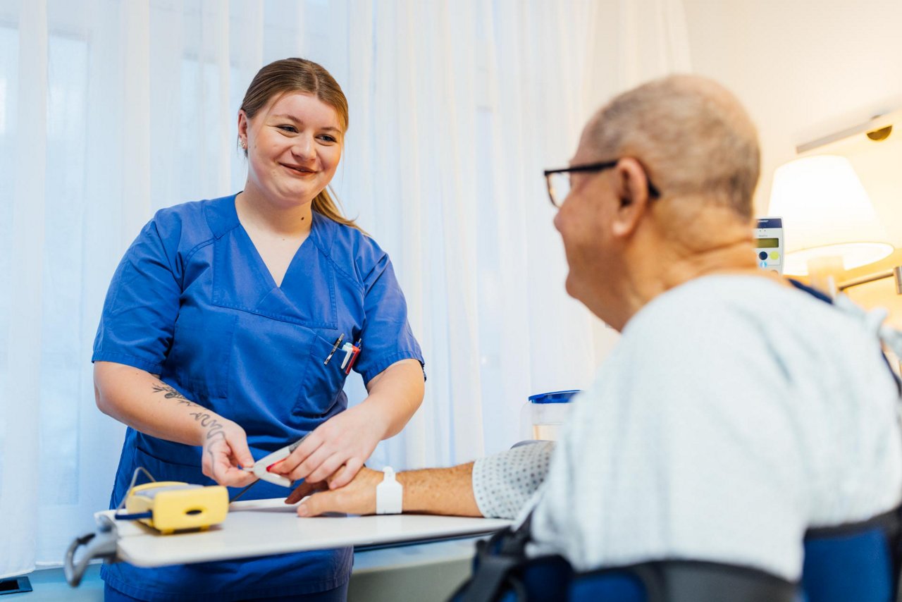 Eine KPH Auszubildende misst im Rahmen einer Pulsoximetrie den Sauerstoffgehalt des Blutes eines Patienten.