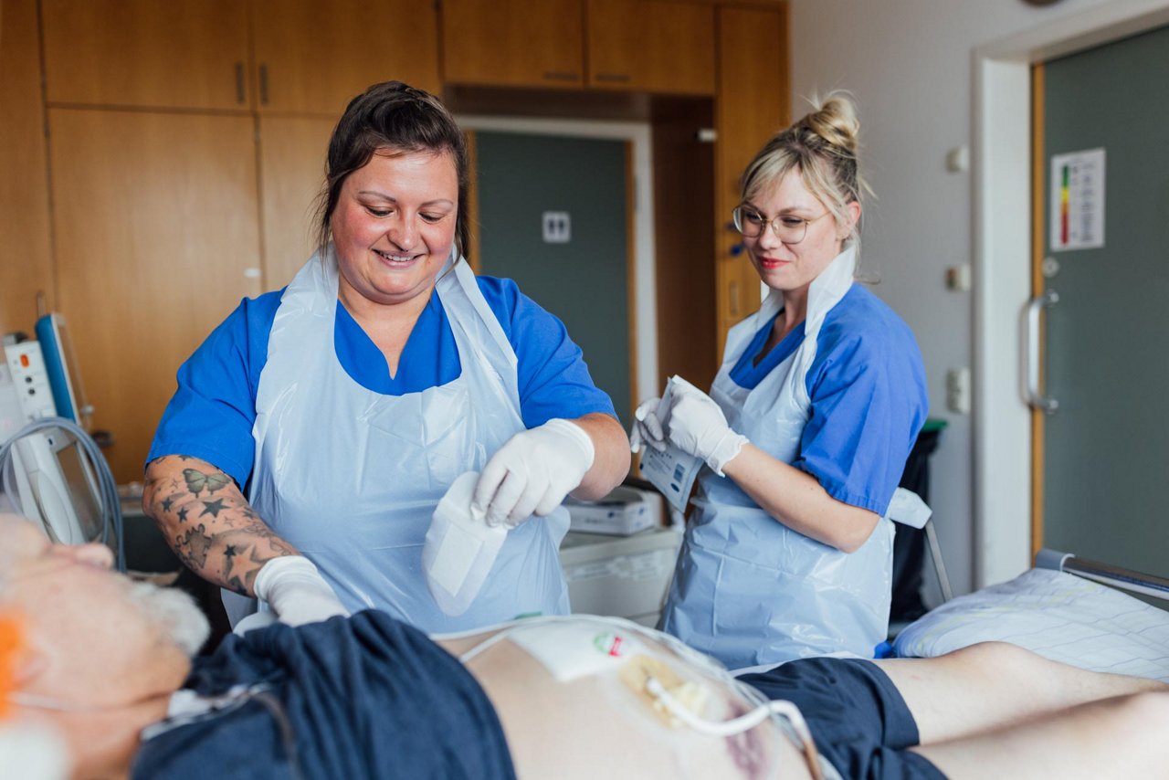 Hier versorgen die beiden Pflegekräfte die Wunde eines Patienten