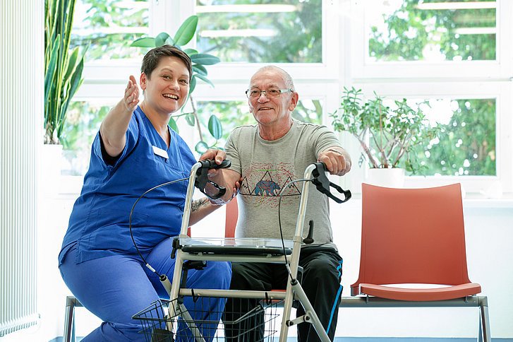 Krankenpflegerin mit Patient beim Mobilitätstraining