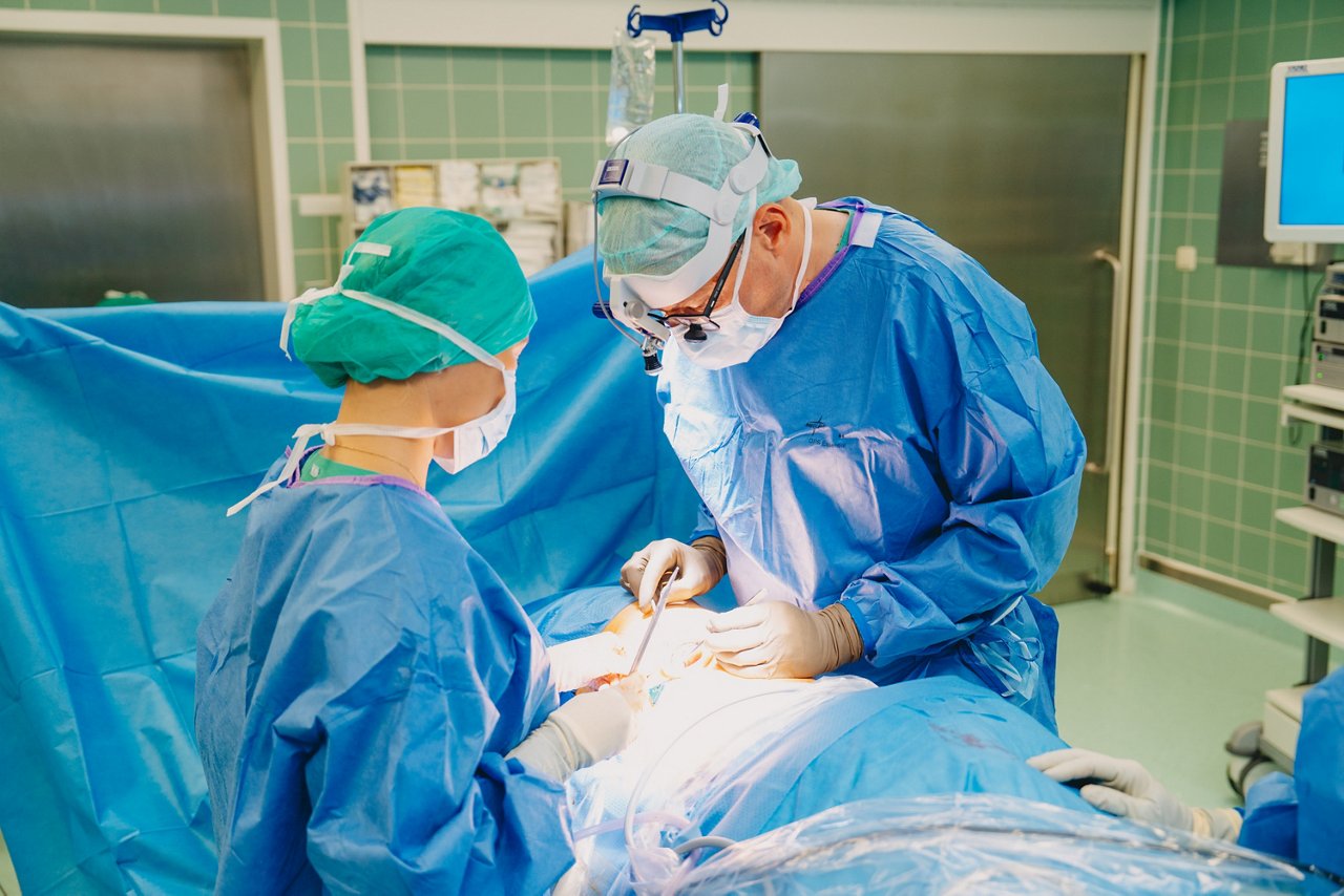 Lungenoperation Zwei Äzte stehen im Operationssaal über den Patienten gebeugt