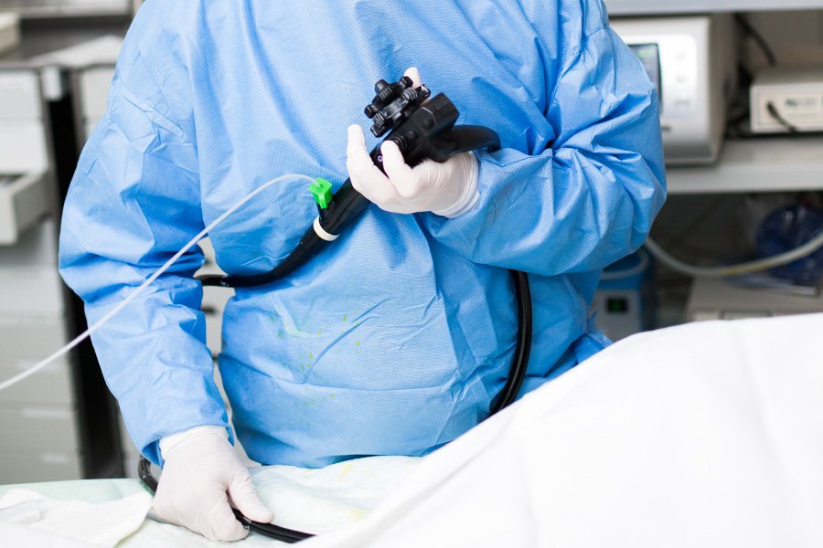 Ein Arzt hält ein Endoskop in der Hand und führt eine Untersuchung durch