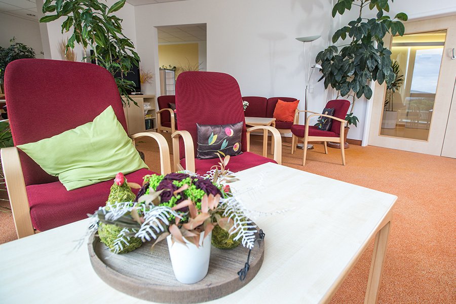 Offener, heller Raum mit Stühlen und Tischgedeck