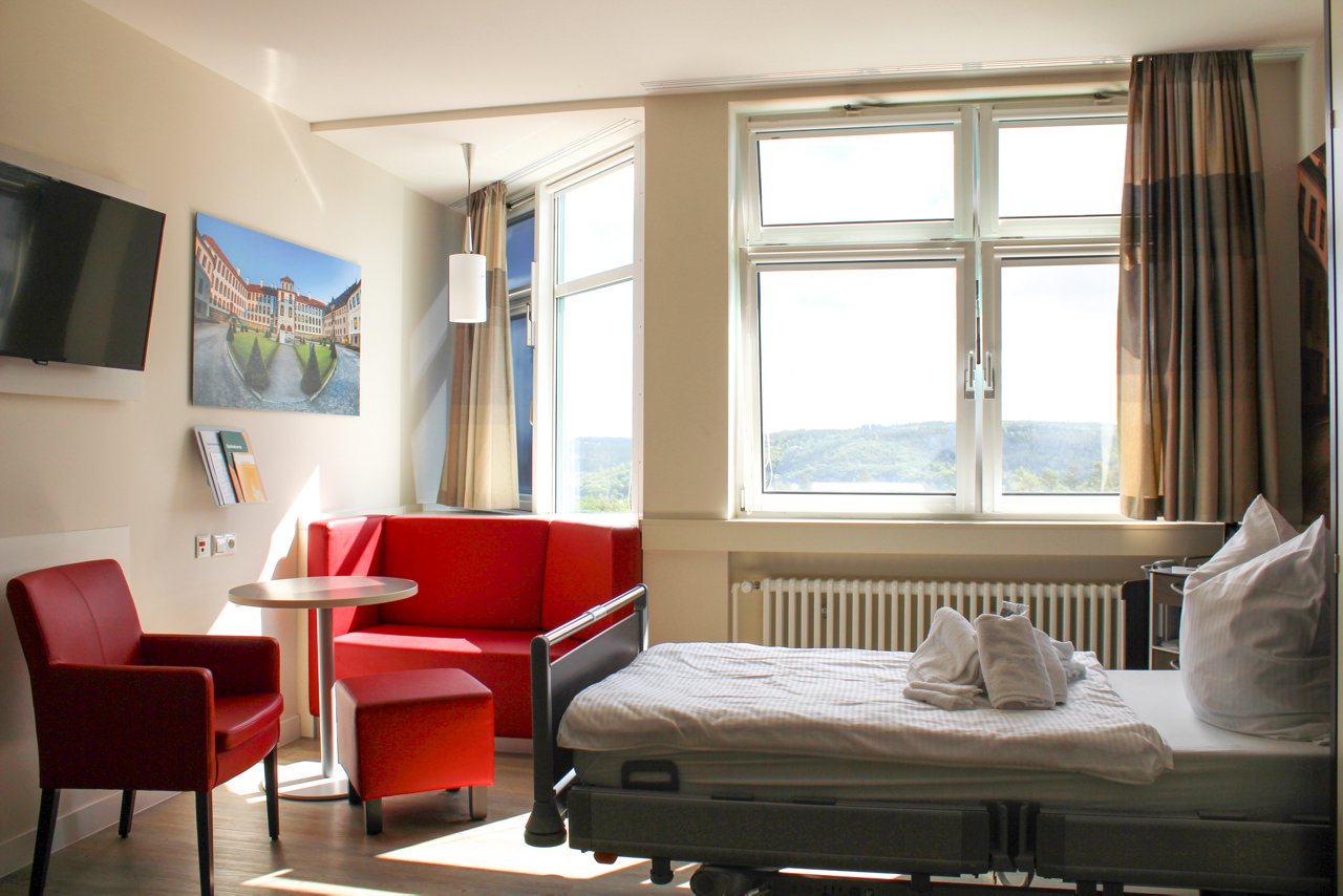 Einbettzimmer der Wahlleistungsstation mit Sitzgelegenheit und Ausblick aus dem Fenster.