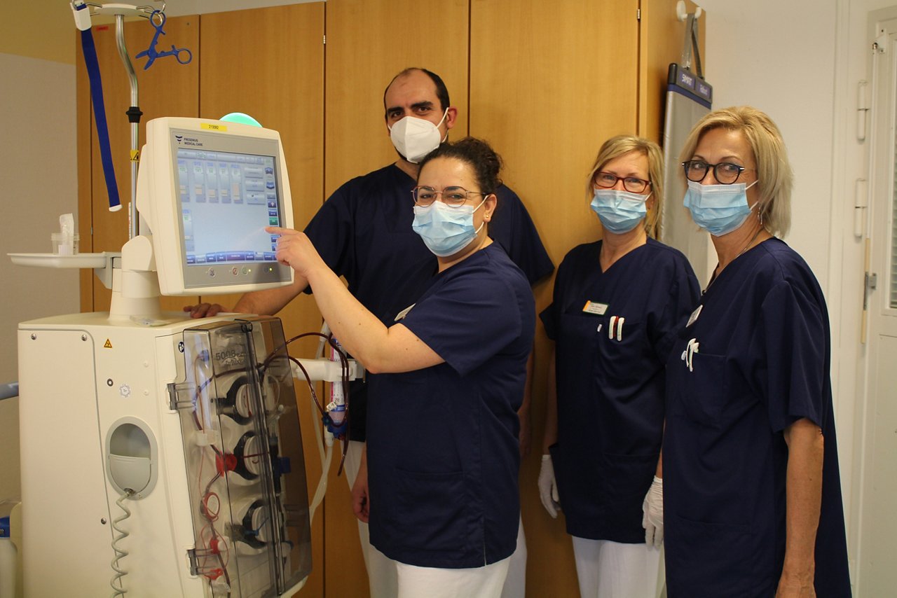 Team der Dialyse steht vor dem Dialysegeraet.