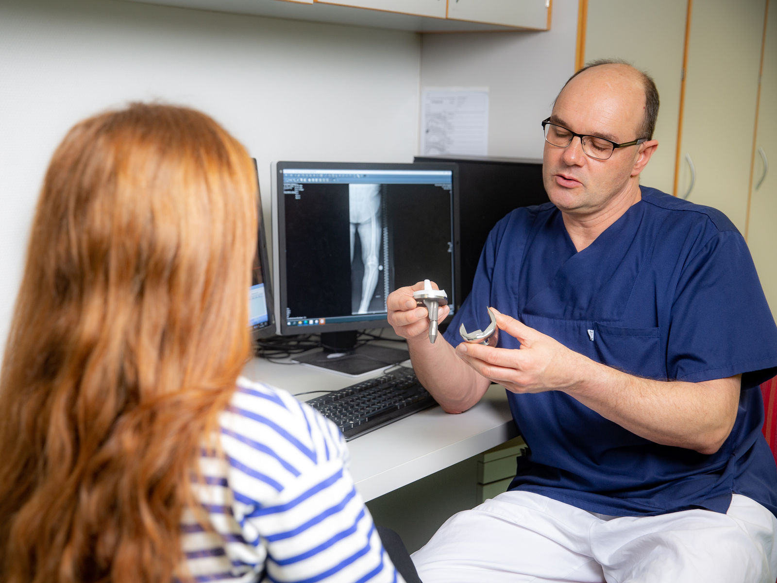 Ein Arzt bespricht mit seiner Patienten den Kniegelenkersatz