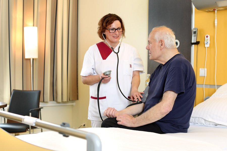 Patient in Einbettzimmer Wahlleistung bei Blutdruckmessung