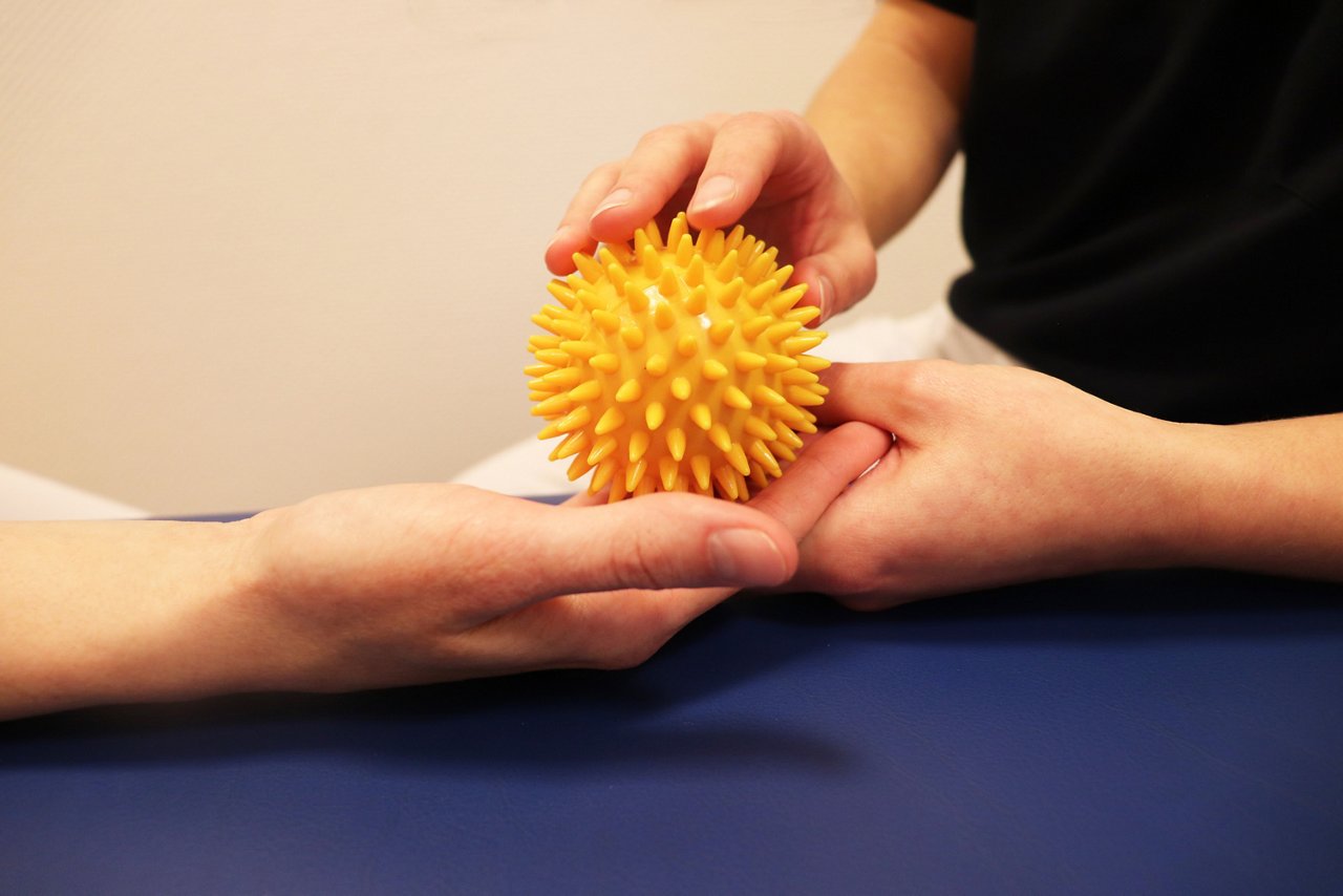 Closeup Igelball zur Ergotherapie auf Hand geführt von Ergotherapeutin