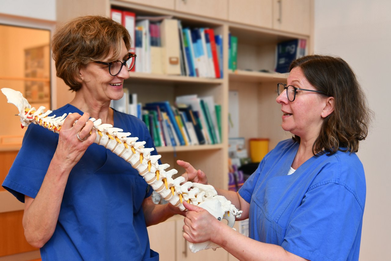 Ärzte Schmerztherapie im Gespräch Wirbelsäule lachend