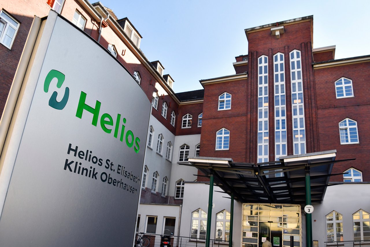 Außenansicht des Klinikgebäudes mit Stele vor dem Haupteingang