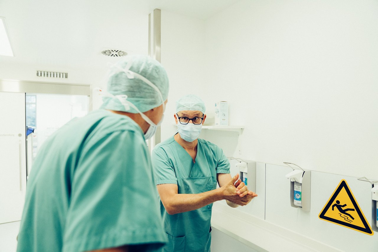Zwei Ärzte unterhalten sich während sie ihre Hände desinfizieren