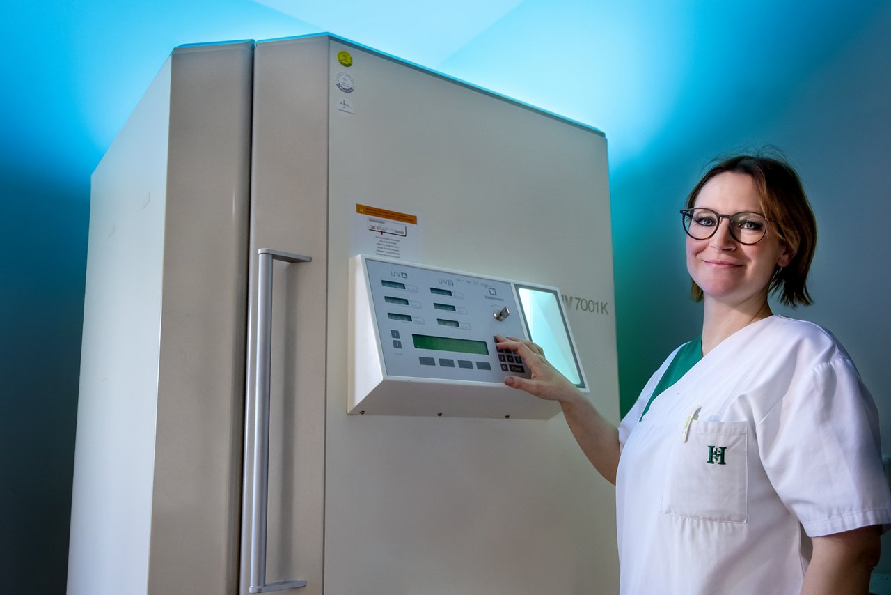 Pflegefachfrau bedient das UV-Licht der Hautklinik