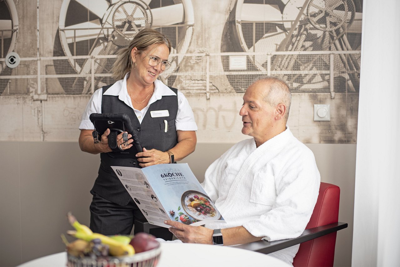 Patient im Gespräch mit Servicekraft