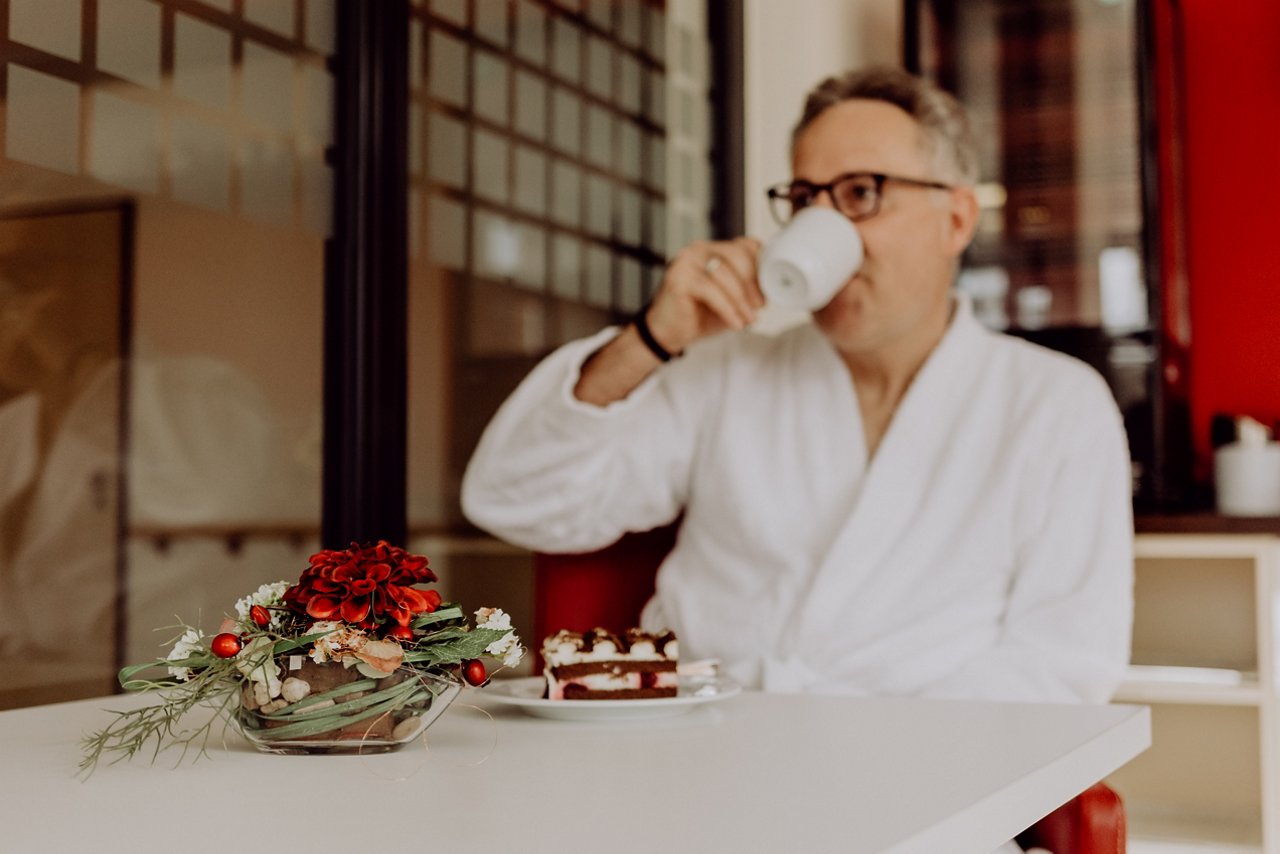 Privatklinik-Patient trinkt Kaffee und isst Kuchen in der Lounge