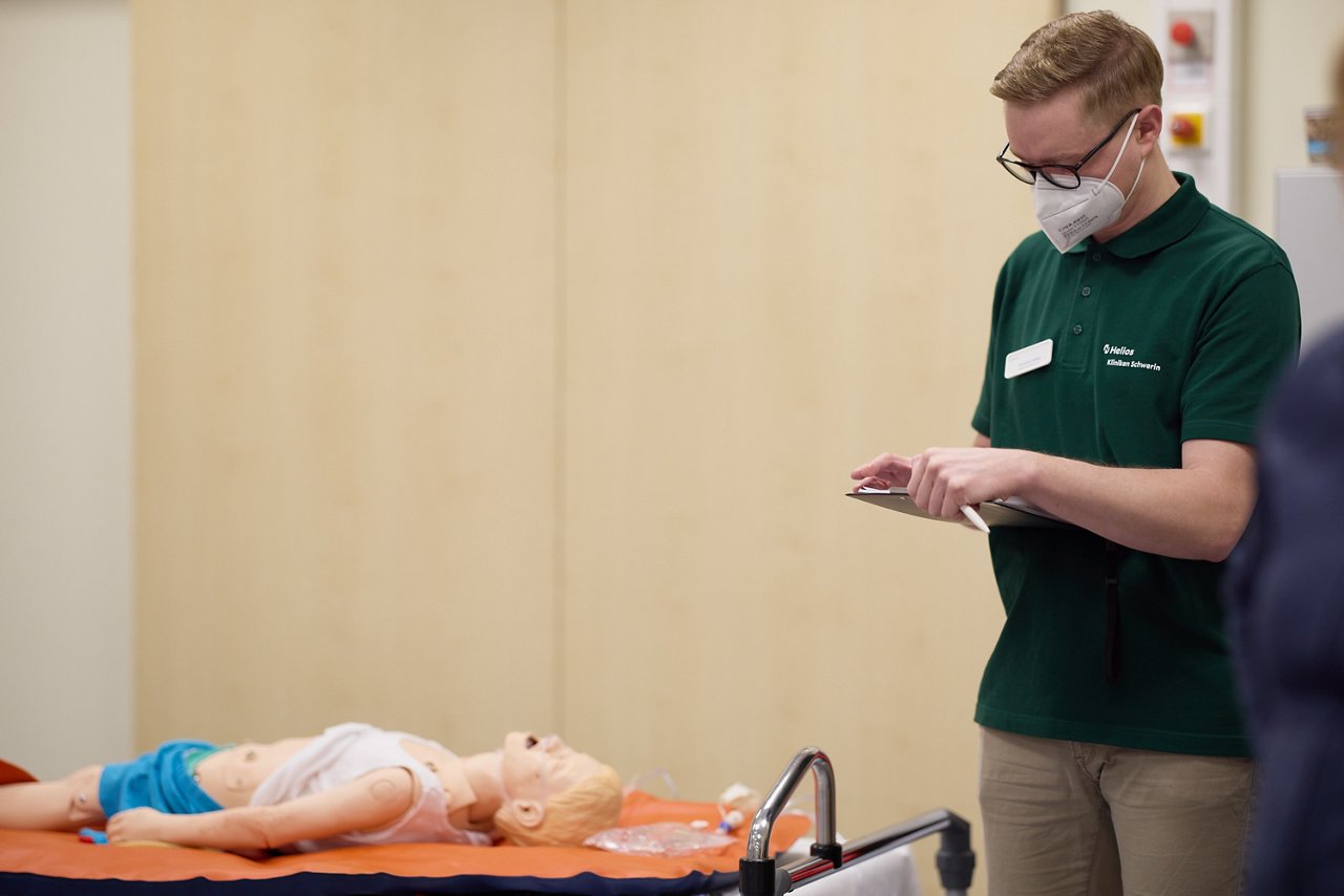 Simulationstrainer und Kursteilnehmer:innen während einer Übung