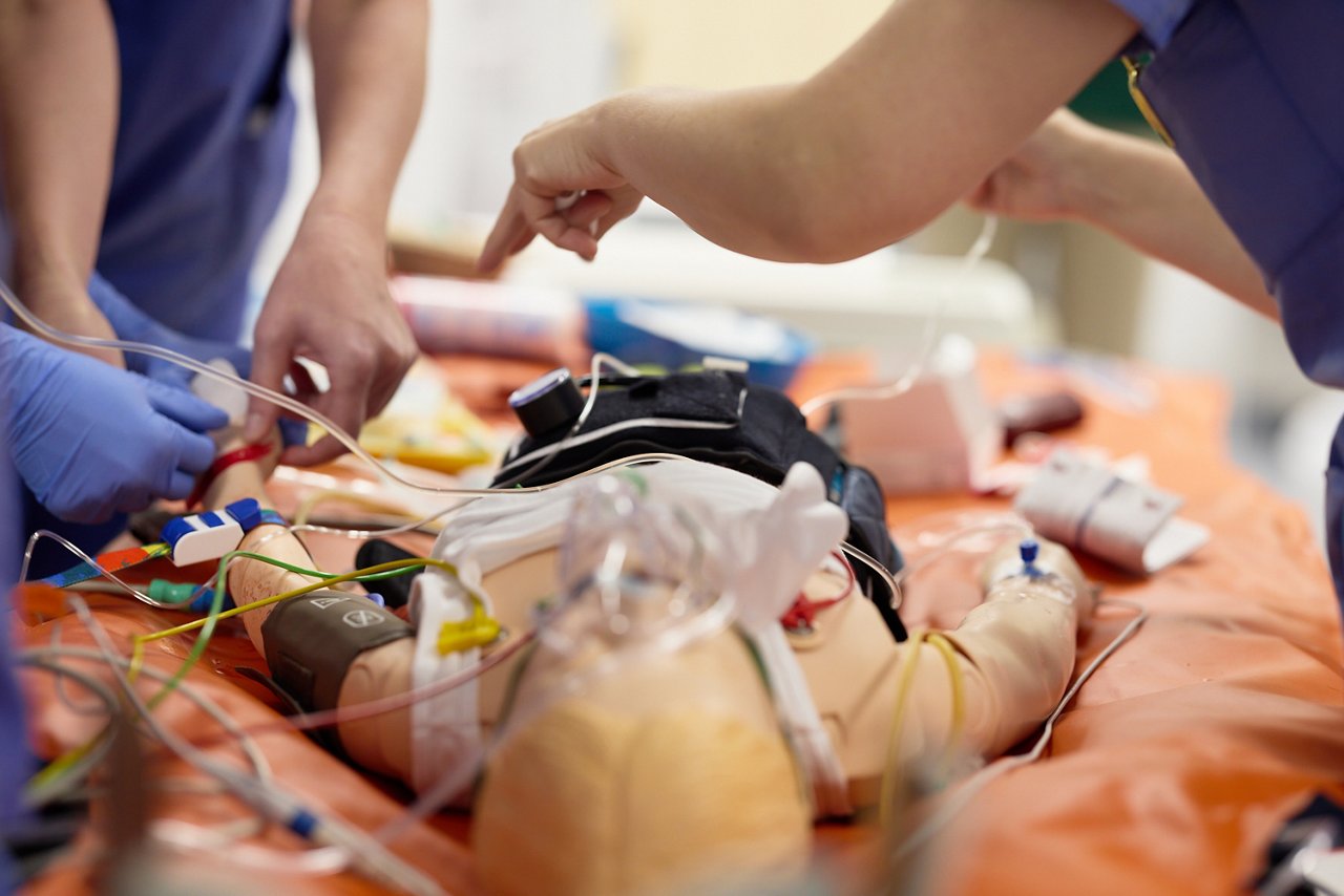 Simulationstrainer und Kursteilnehmer:innen während einer Übung