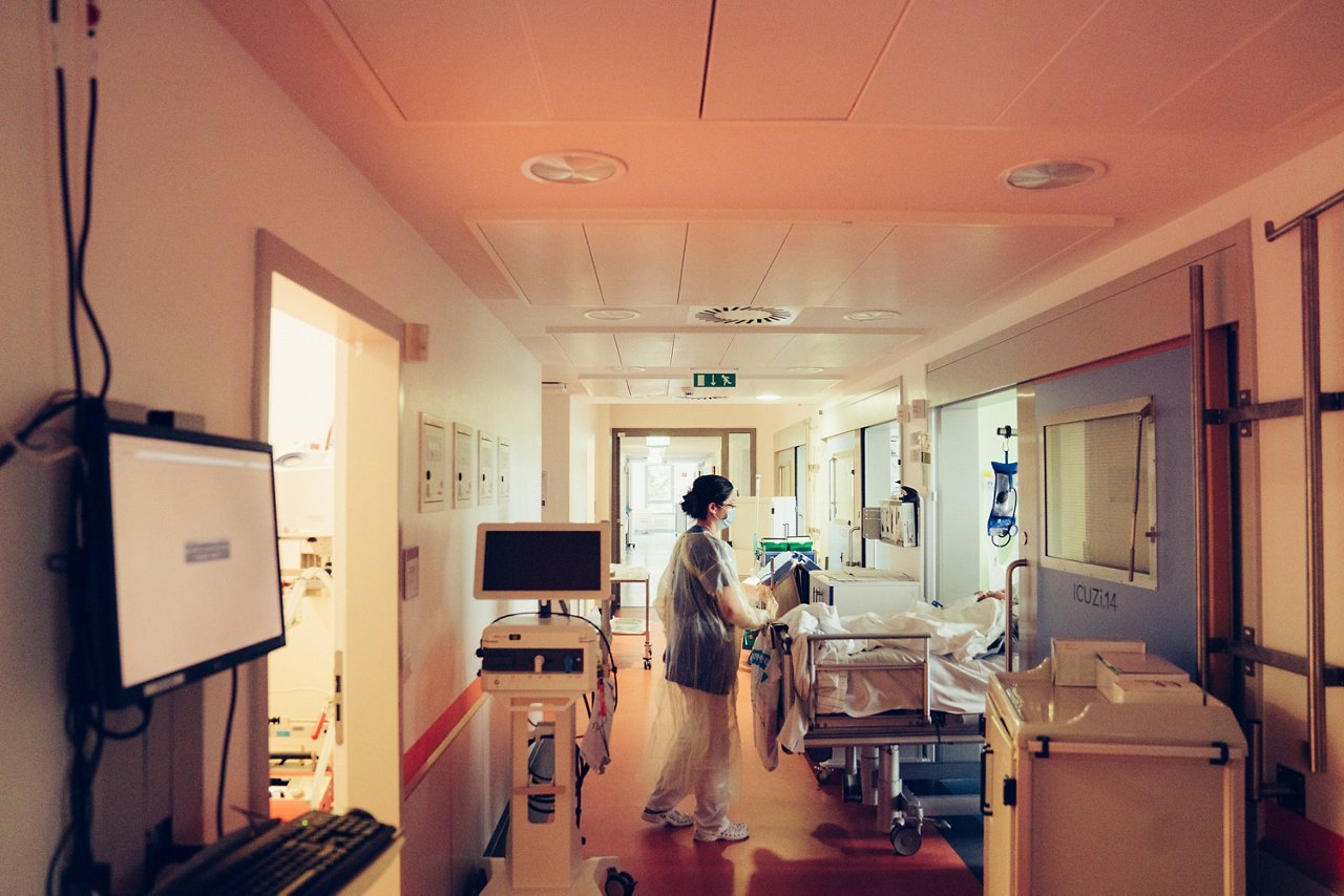 Eine Pflegerin schiebt ein Krankenbett vom Flur in den OP