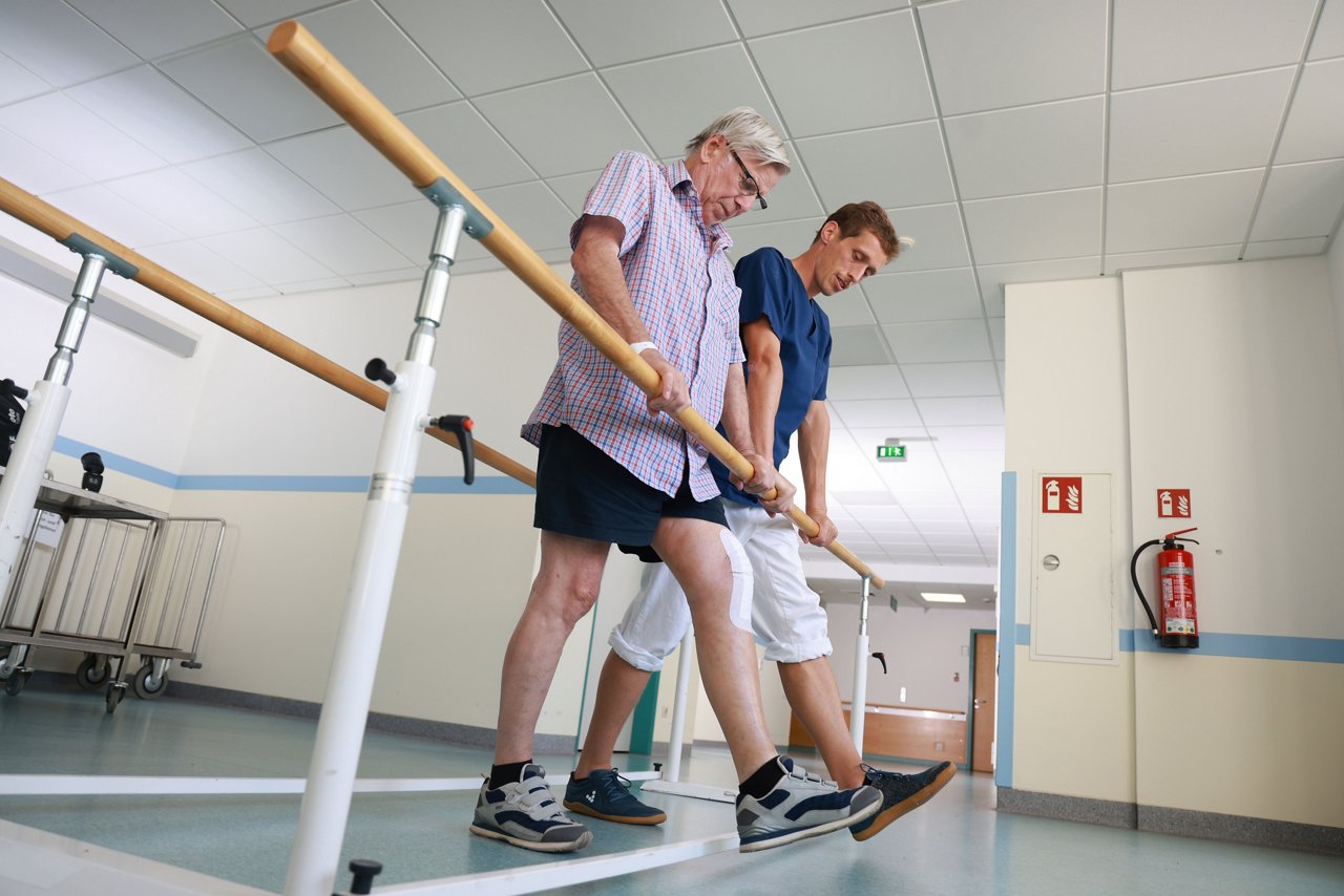 Bewegungsübungen - Physiotherapeut mit Patient am Barren