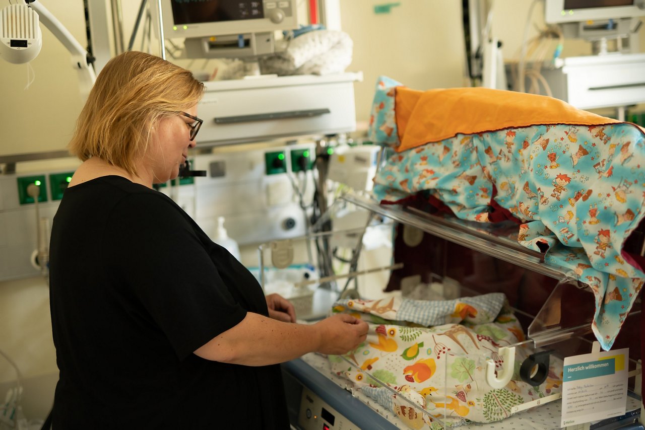 Elternberaterin Gesa Groth schaut auf ein Baby im Inkubator
