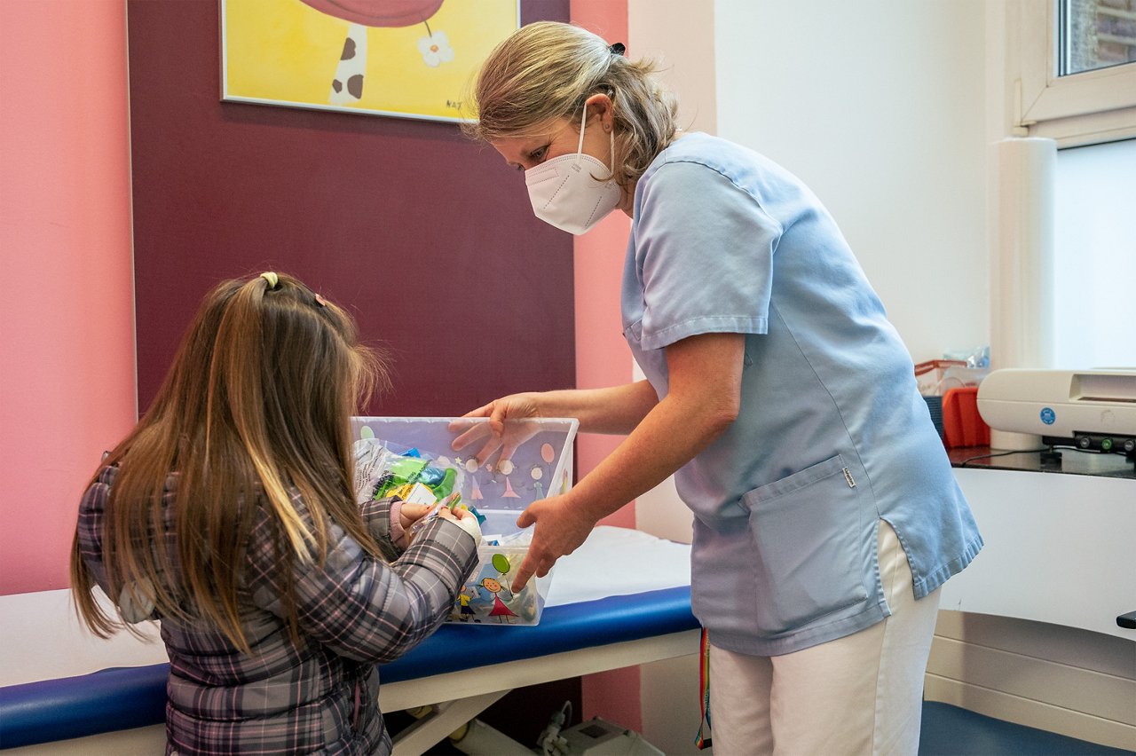 KinderZNA_Pflegekraft mit kleiner Patientin, die sich Spielzeug aussucht