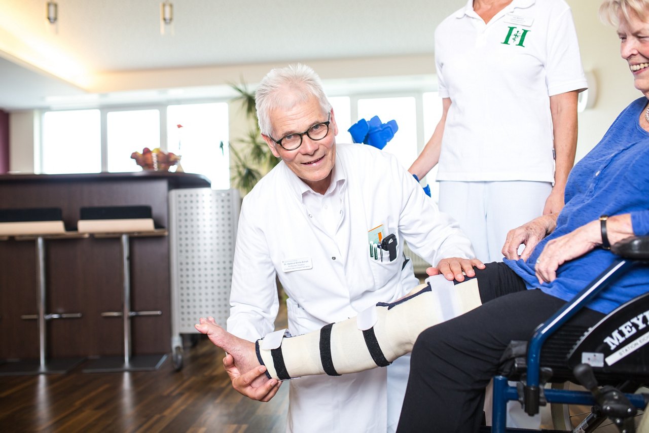 Arzt behandelt Bein von Patientin