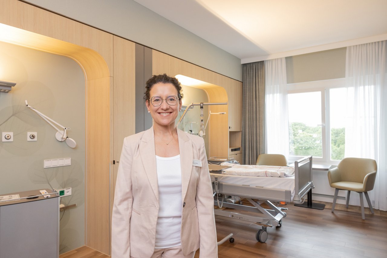 Wahlleistungsmanagerin steht im HP-Patientenzimmer