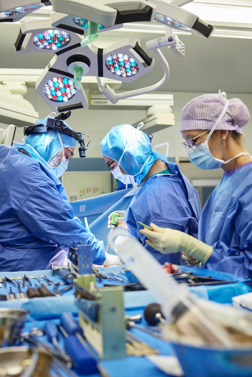 OP Medizinisches Team bei der Durchführung eines Eingriffs in einem hellen, modernen Operationssaal