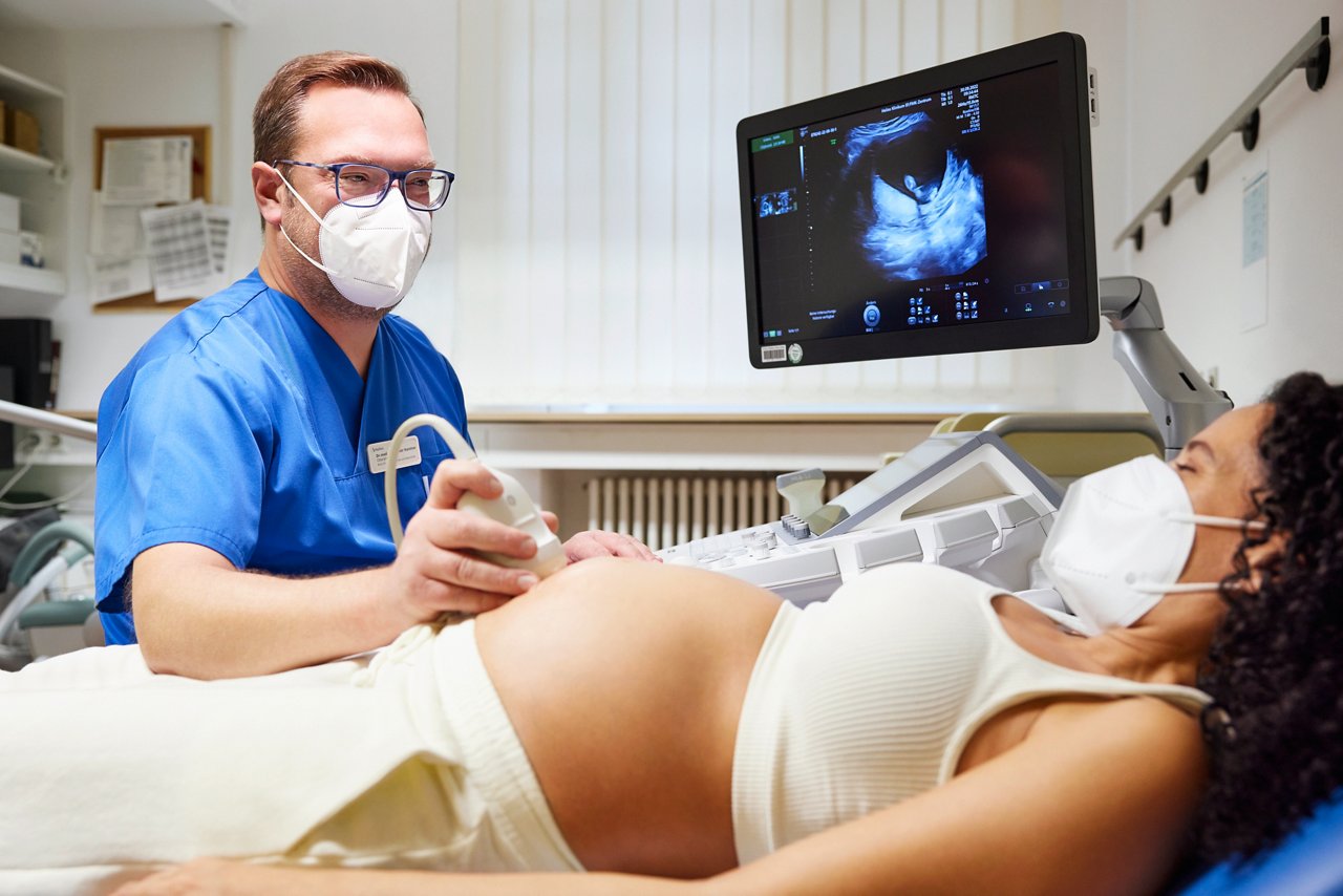 Schwangere Frau bei einer Ultraschalluntersuchung Motiv der Patientenkampagne 2022  #BesserZuHelios Arzt untersucht eine schwangere Frau mit Ultraschall