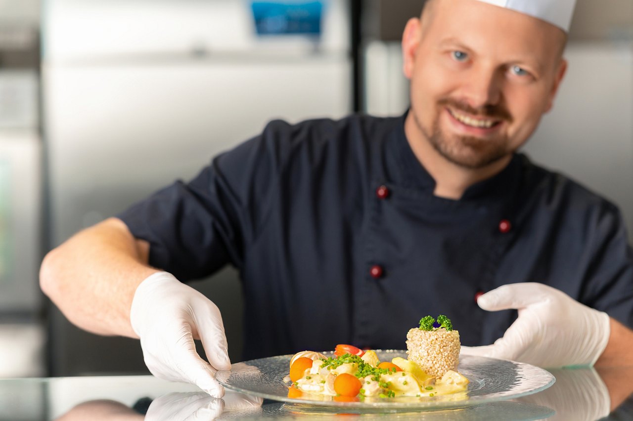 Küchenchef David Ochs serviert Gericht in der Cafeteria