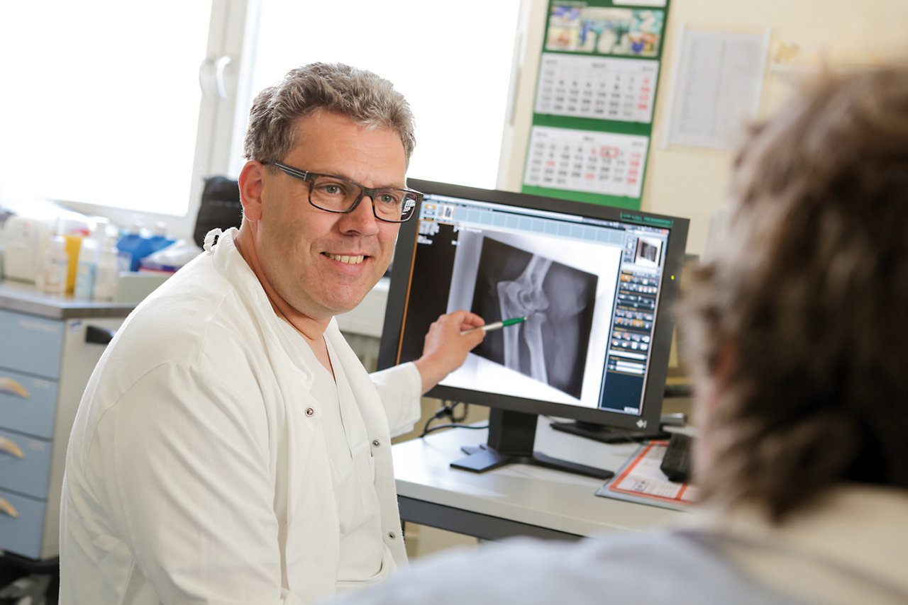 Orthopäde erklärt Patienten Röntgenbild